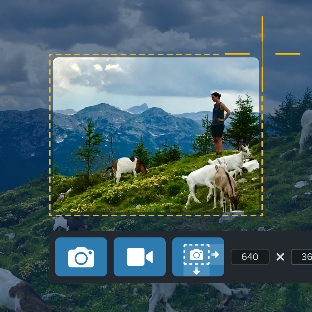 Someone capturing a screenshot of a mountain scene with a person and goats using Snagit, showing cropping tools on the screen.