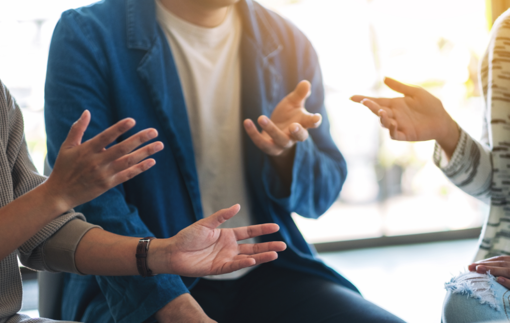 Close-up of people gesturing with their hands during a conversation.